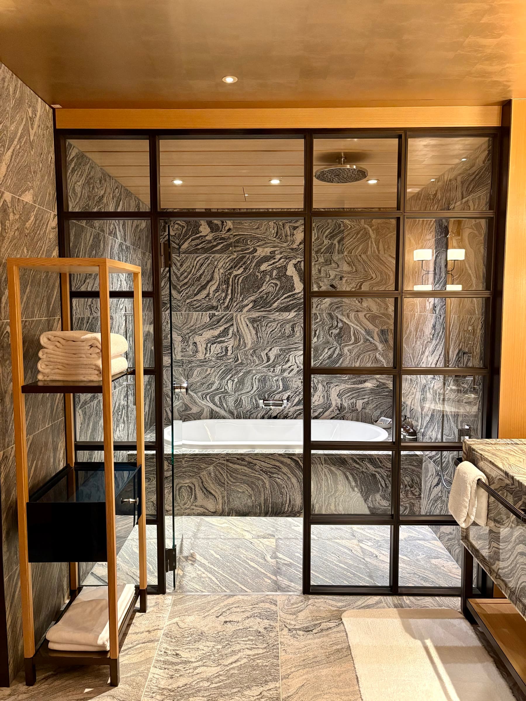 Phòng tắm đá marble với bồn tắm và vòi sen